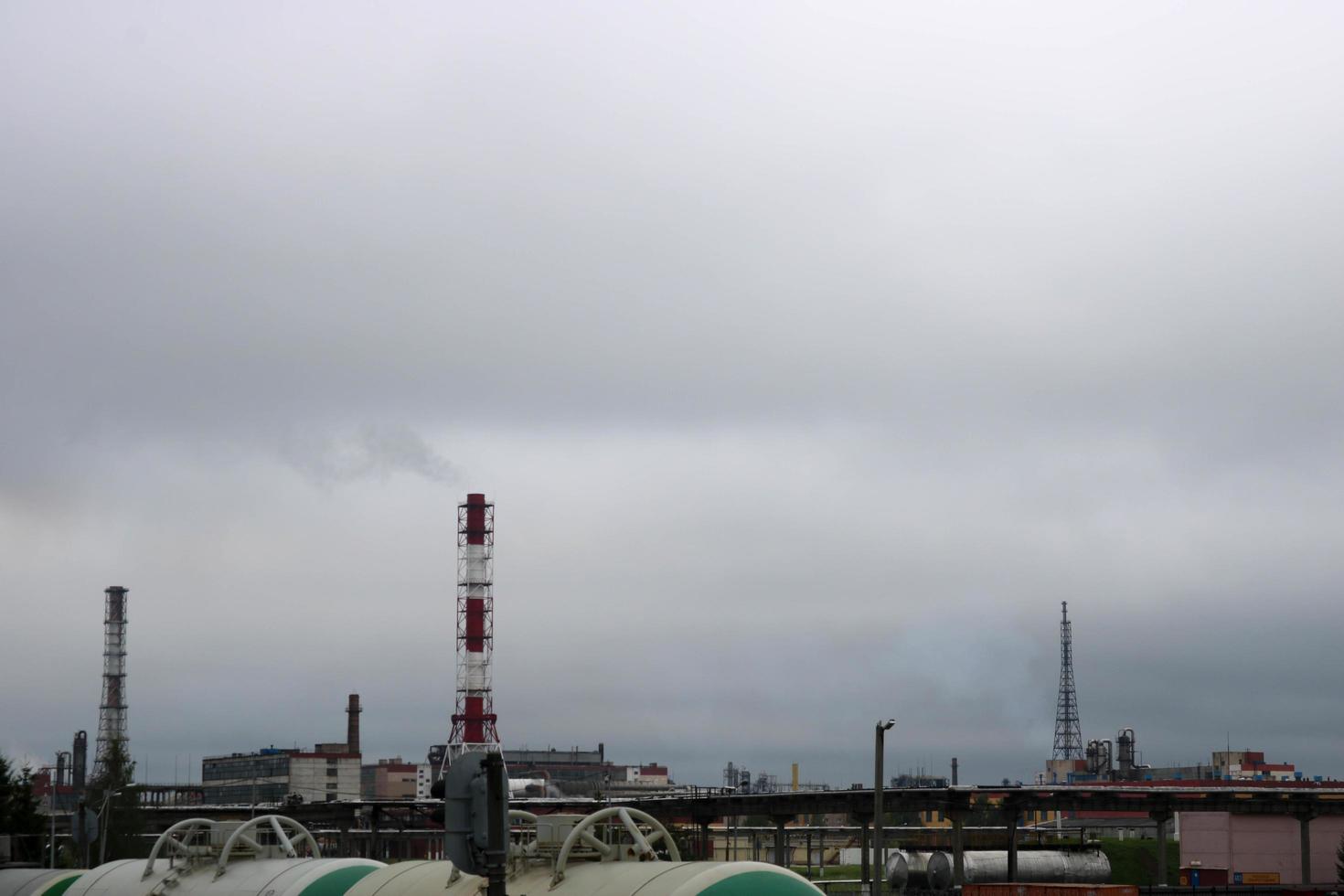 een groot hoog niet-ecologisch metalen ijzer pijp voor de emissie van rook gas- Bij de petrochemisch chemisch raffinaderij industrieel raffinaderij tegen de achtergrond van de blauw lucht foto