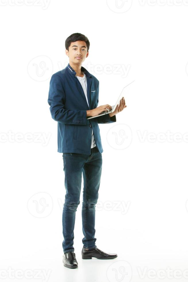 jong mannetje junior hoog school- leerling, 15 jaren oud, Aziatisch jong Mens in gewoontjes kleren Holding een laptop computer voor aan het studeren en zoeken. foto
