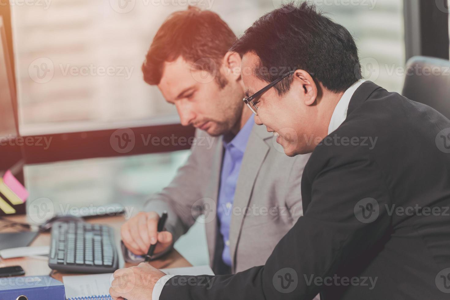 twee bedrijf Mens pratend met partner mengen ras Aziatisch en Kaukasisch mannelijk, baas uitvoerend werken helpen zorg met werknemer in kantoor. foto