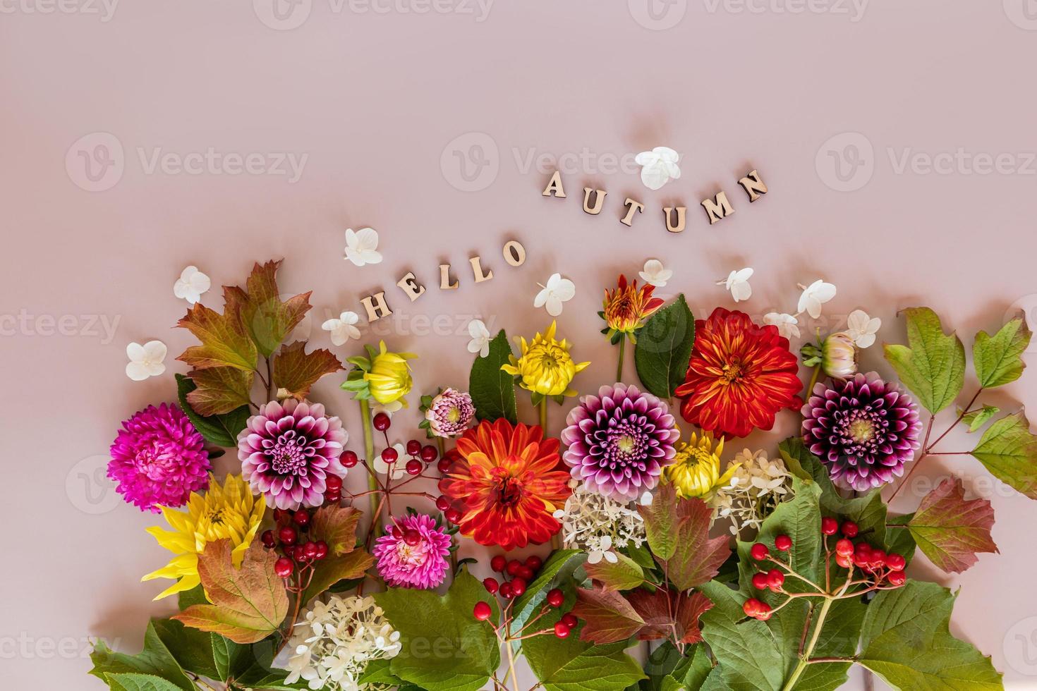 chique herfst samenstelling van helder veelkleurig tuin bloemen en houten brieven met de tekst -Hallo herfst. top visie. vlak leggen. beige achtergrond. foto
