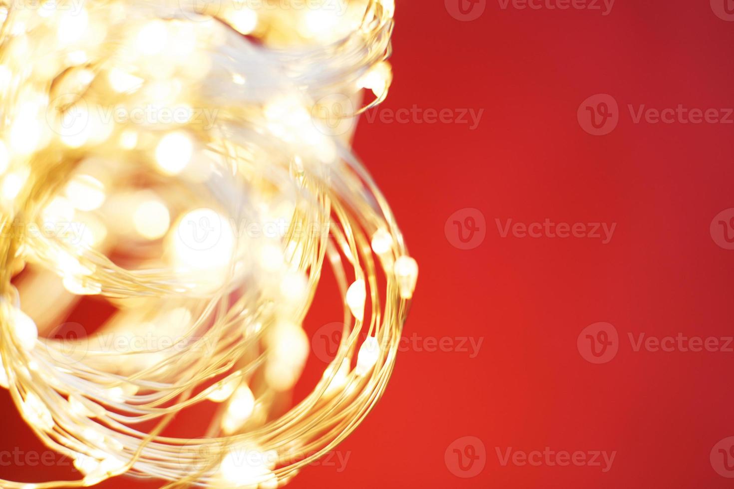 Kerstmis prachtig glimmend goud slinger Aan een rood achtergrond. fonkeling feestelijk achtergrond foto