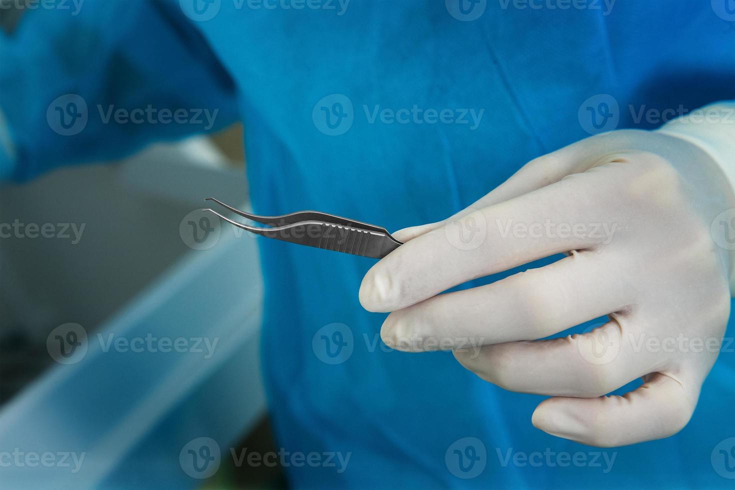 dokter in latex handschoenen Holding de in werking pincet foto