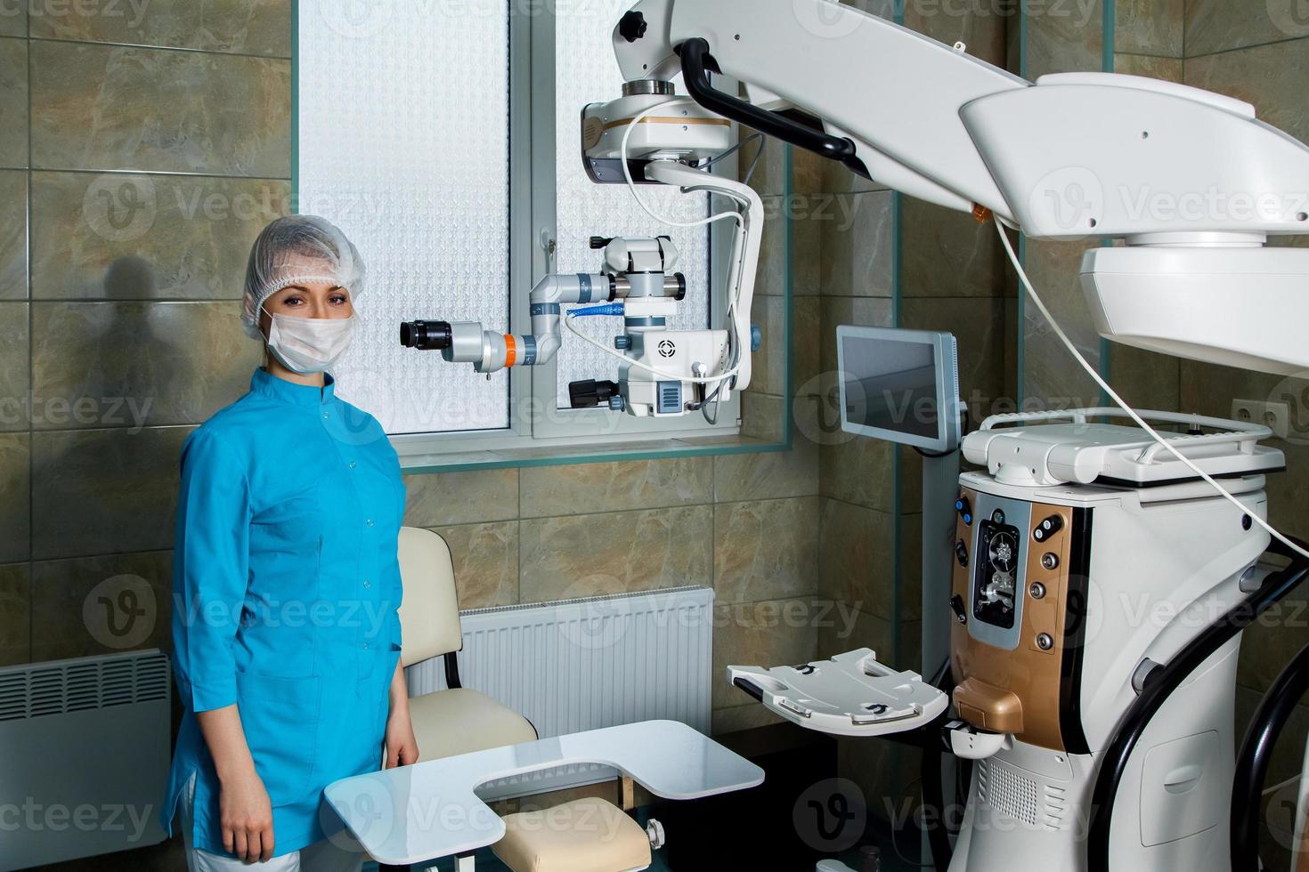 jong vrouw dokter in operatie kamer met chirurgisch microscoop foto