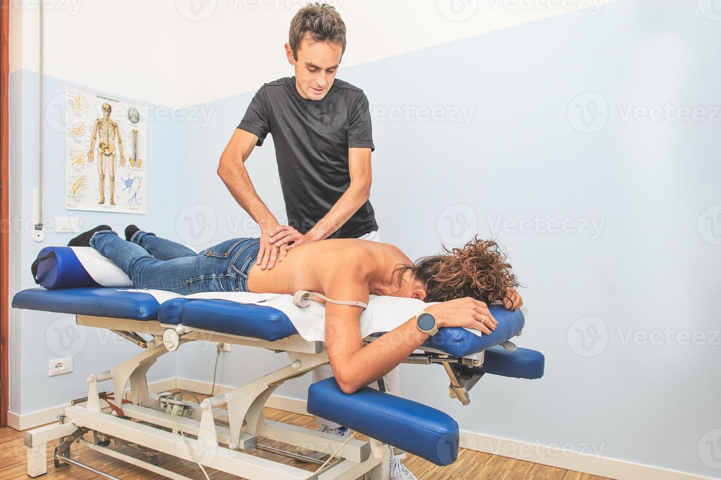 fysiotherapeut en zijn vrouw cliënt gedurende een terug behandeling foto