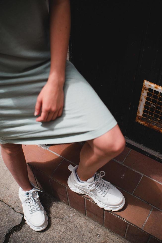 augsburg, Duitsland, 2020 - vrouw met T-shirtjurk en witte sneakers foto