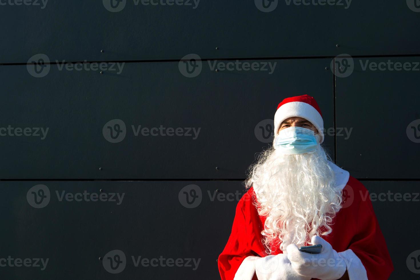 de kerstman claus met wit baard in rood jas in een medisch masker. Kerstmis in de coronavirus pandemie, seizoensgebonden ziekten, sars en longontsteking in de vakantie. bescherming van virussen in de nieuw jaar foto