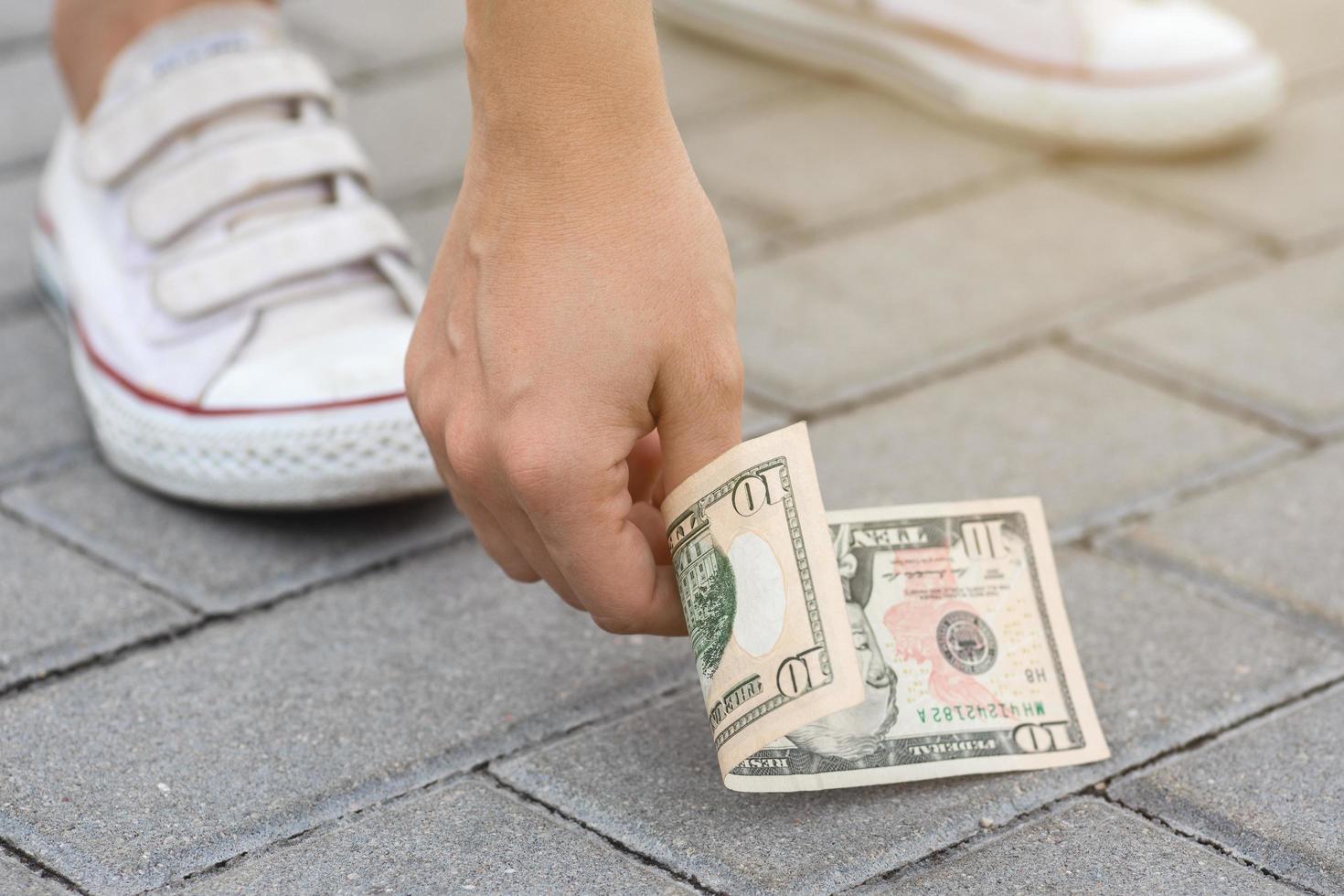 Lucky vrouw is plukken tien dollars bankbiljet van de grond. foto