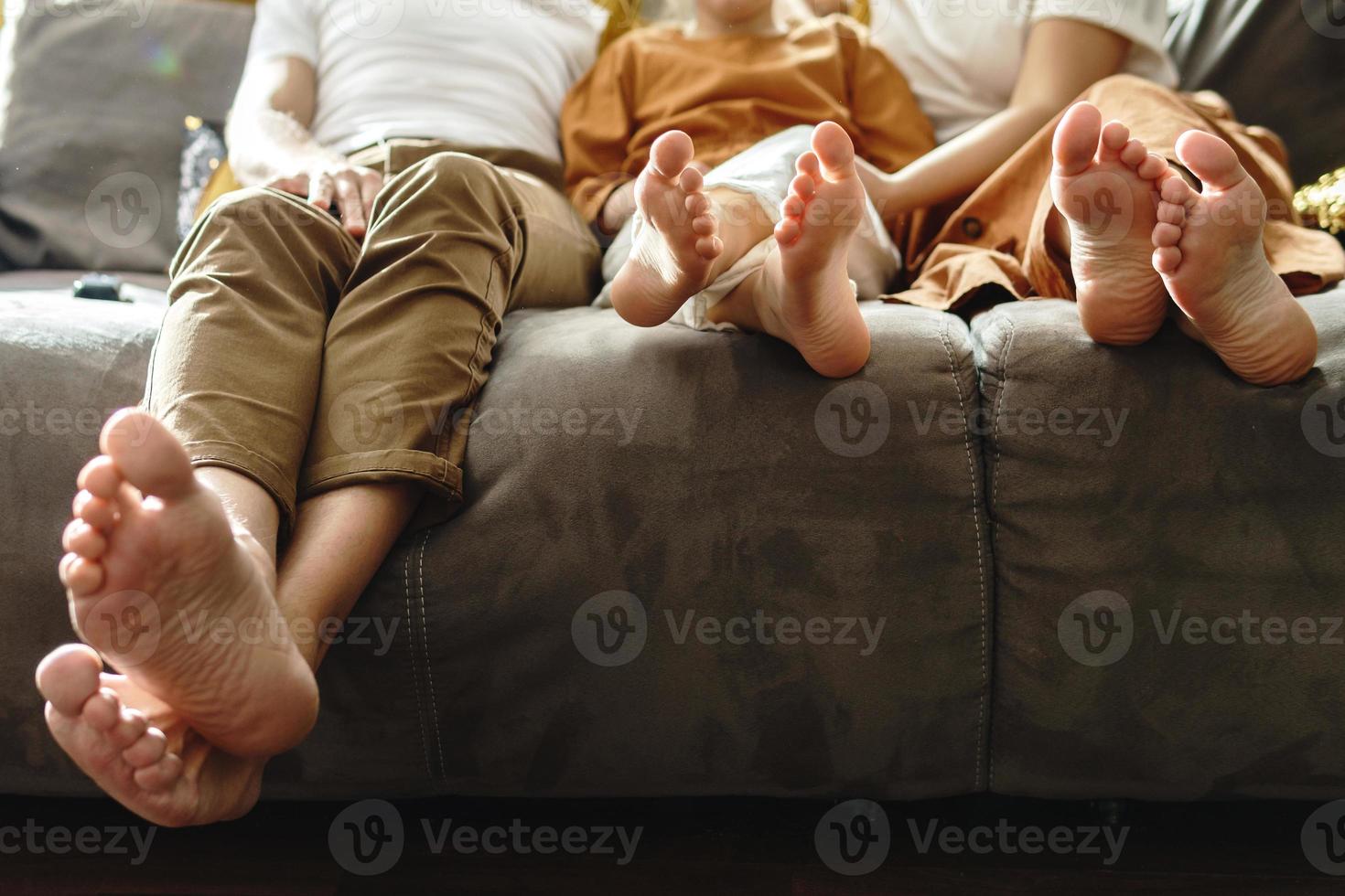 familie zittend Aan een sofa in de leven kamer foto