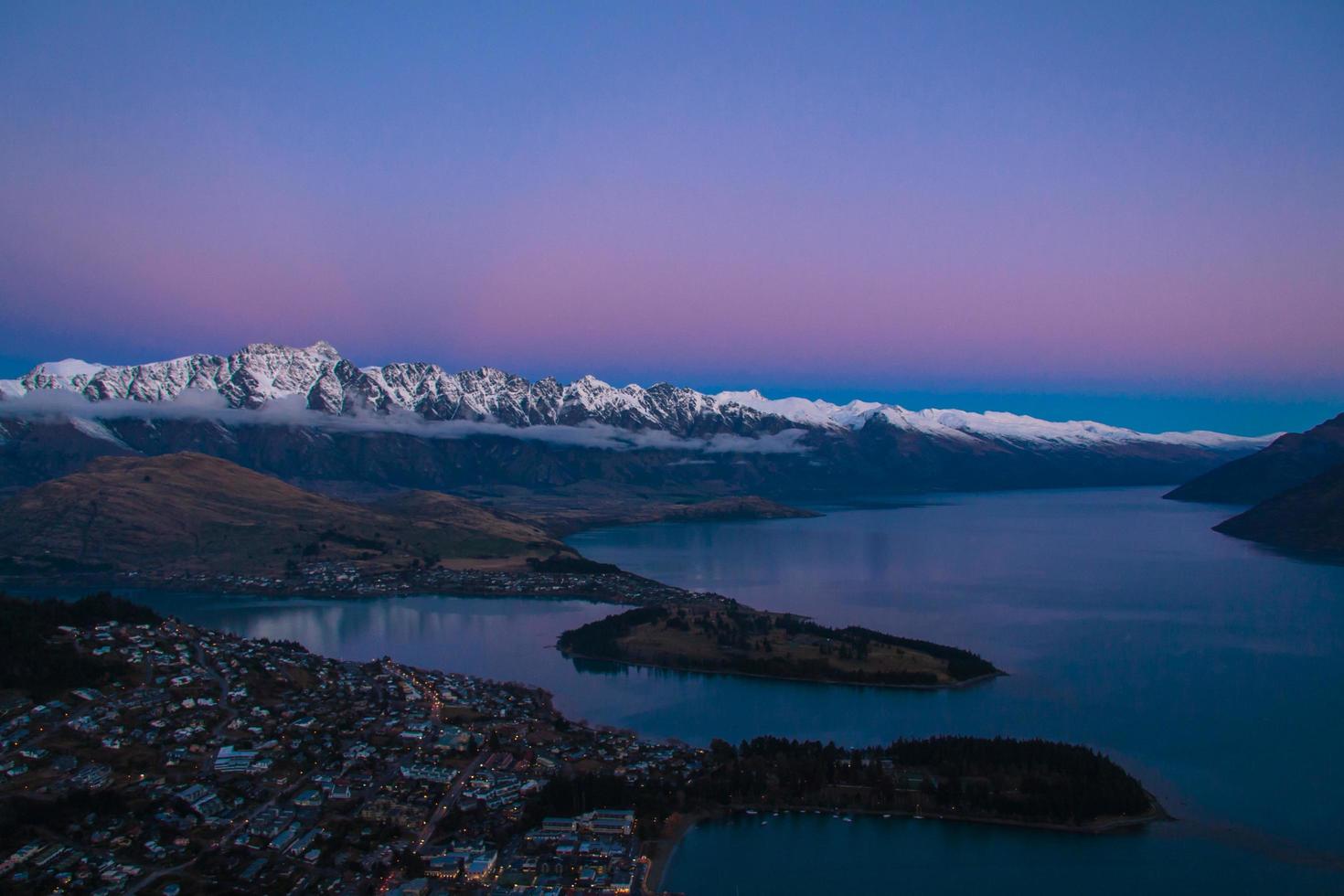 zonsondergang over rivier en besneeuwde bergen foto