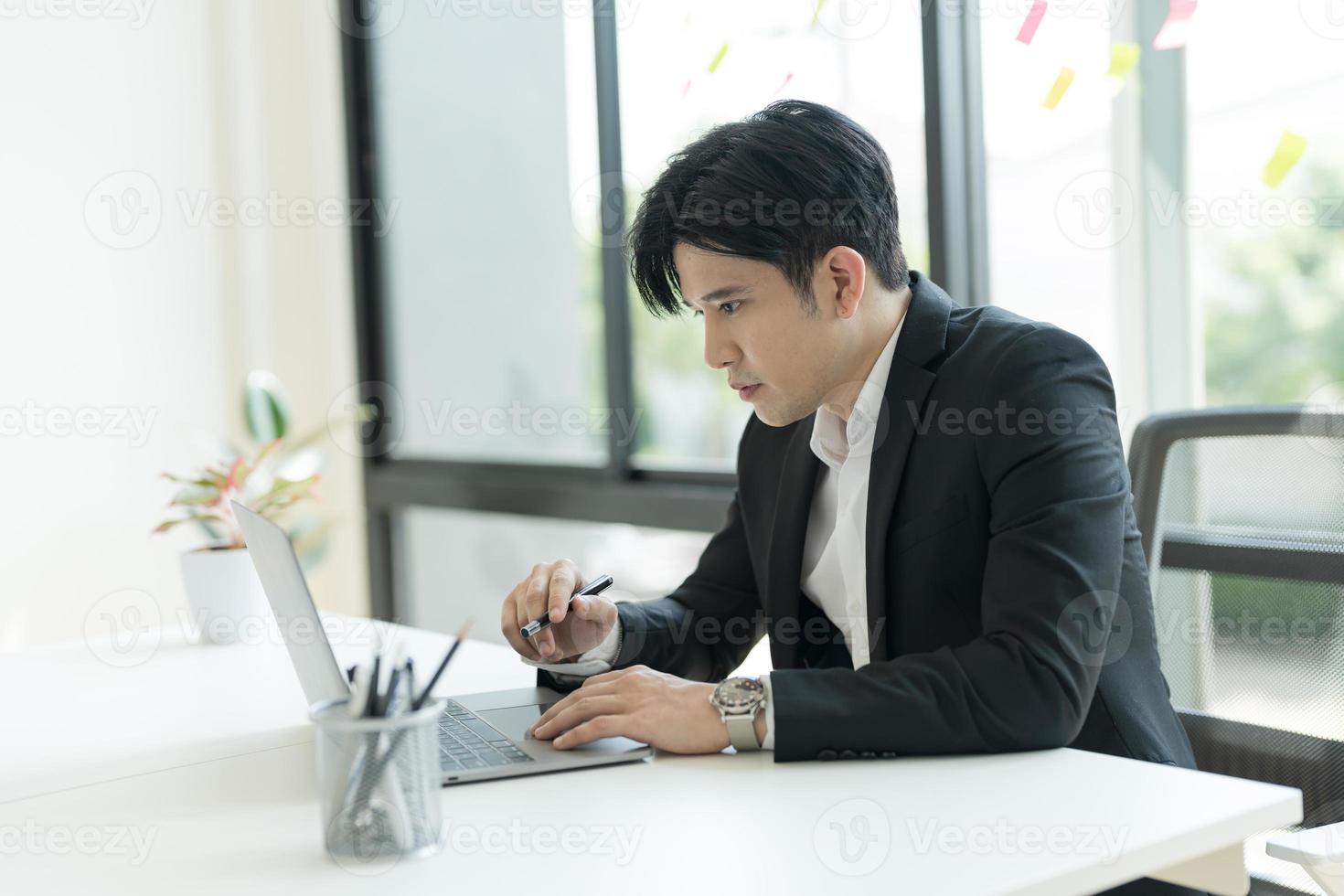 jong zakenman opening een notitieboekje visie e-mails van klanten verzonden. en schrijven naar beneden de details. foto