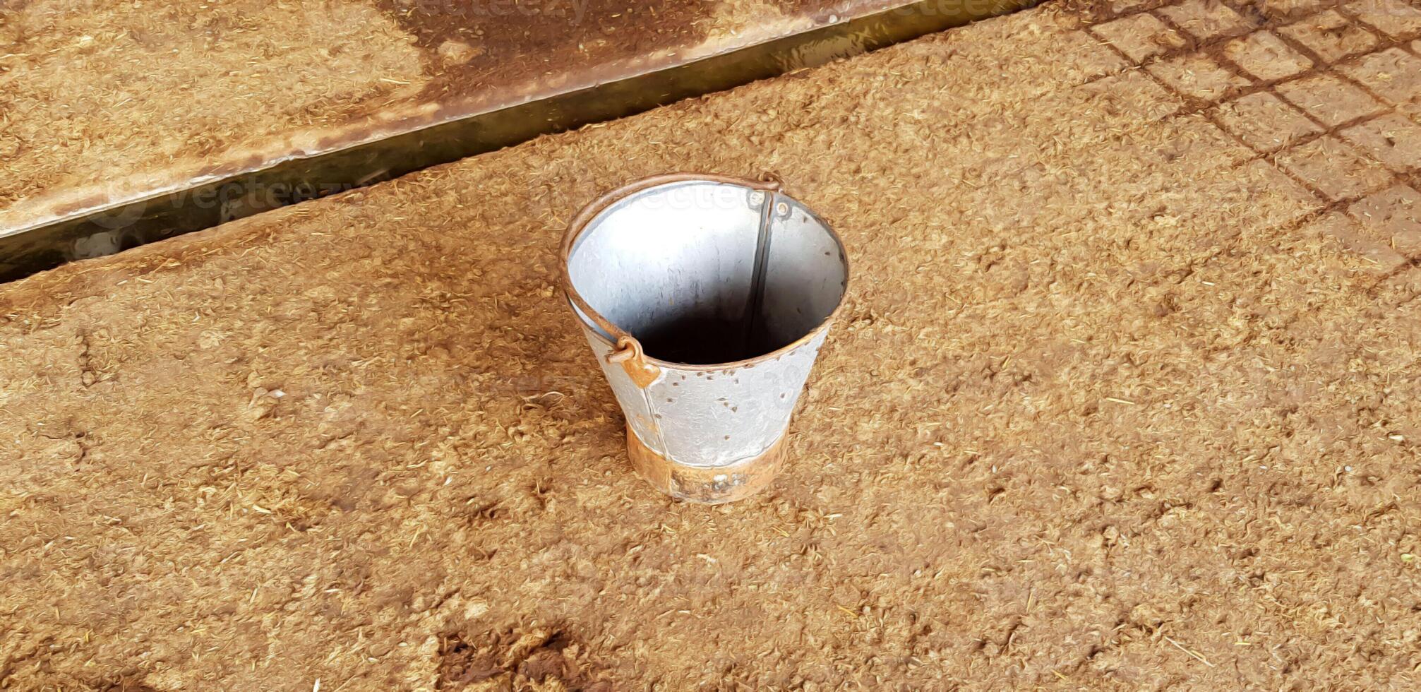 oud rustiek grijs metalen of roestvrij staal emmer geïsoleerd Aan zand getextureerde achtergrond foto