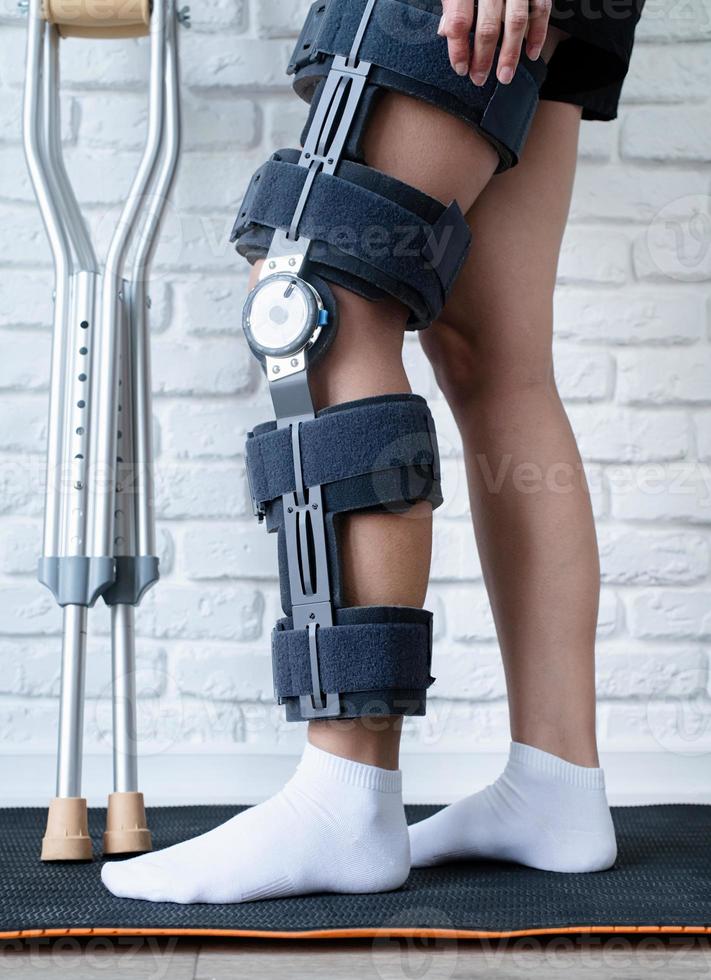 vrouw vervelend knie orthese of knie ondersteuning beugel na chirurgie Aan been foto