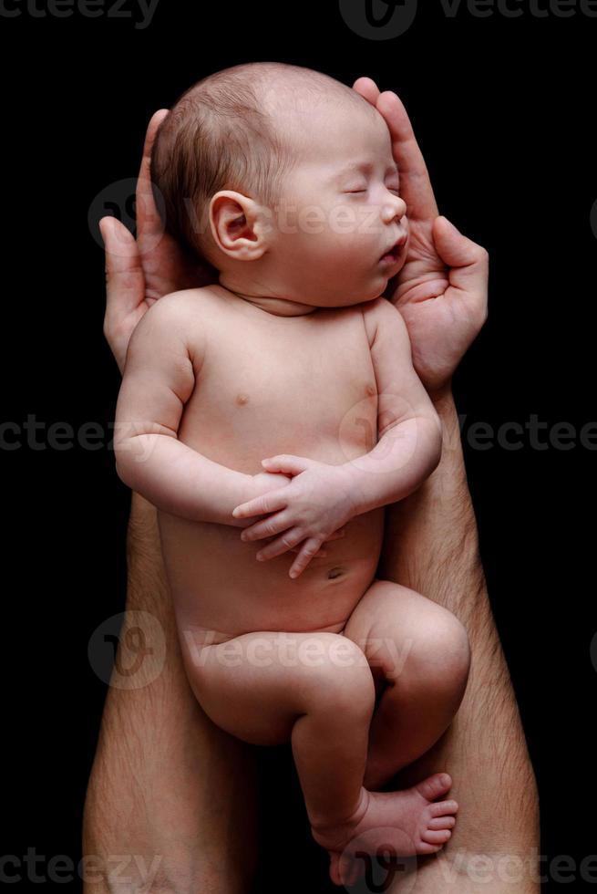 schattig pasgeboren baby aan het liegen in de vader handen foto