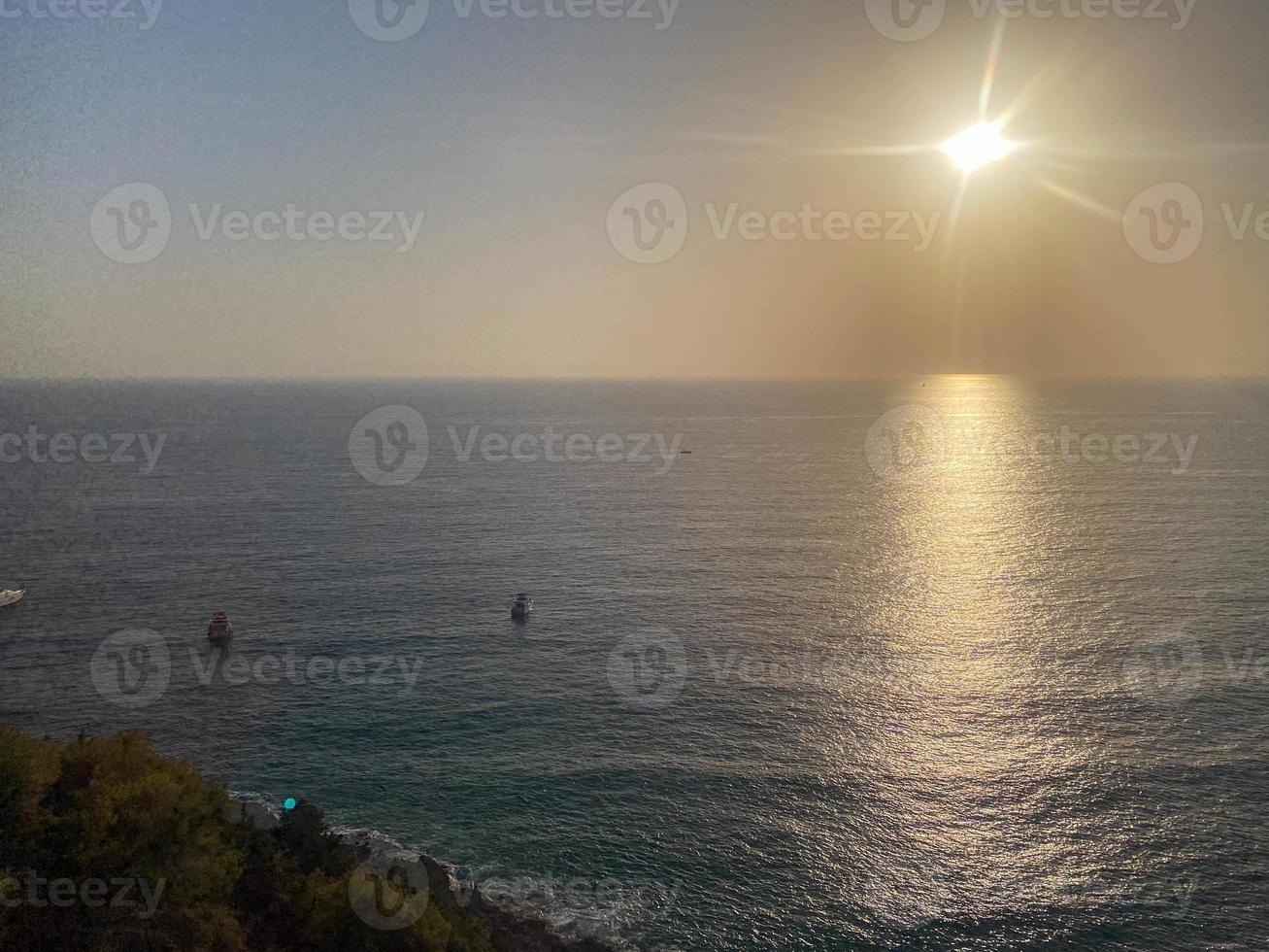 visie van de zee en de zon Bij zonsondergang Aan vakantie in een warm tropisch oosters paradijs land zuidelijk toevlucht foto