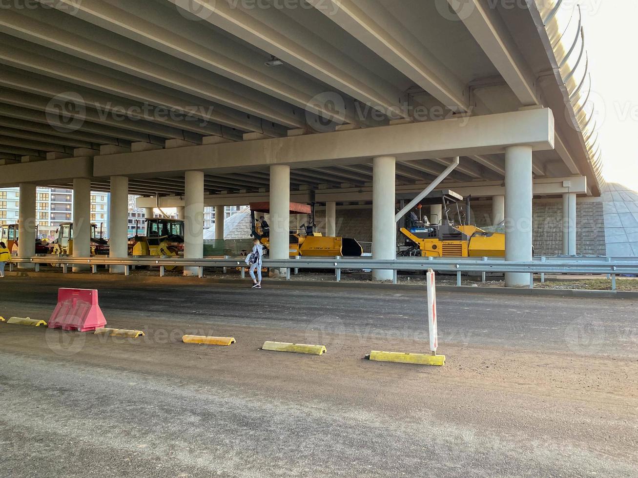 bouw industrieel werk onder de brug en groot snelweg viaduct met de helpen van modern bouw uitrusting zo net zo asfalt rollen foto