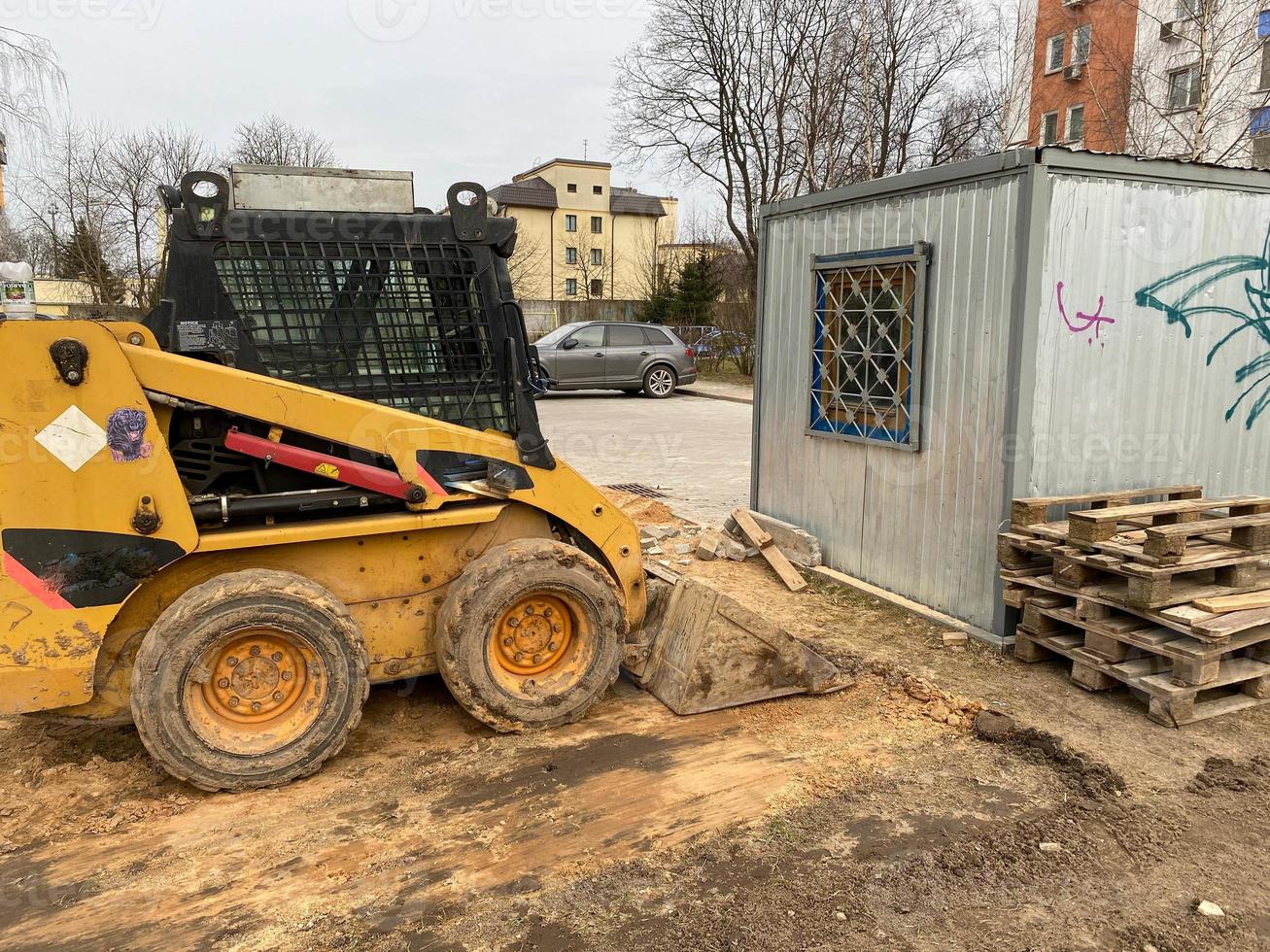 klein maar krachtig geel bouw graafmachine met een emmer. modern bouw uitrusting voor vernieuwing foto