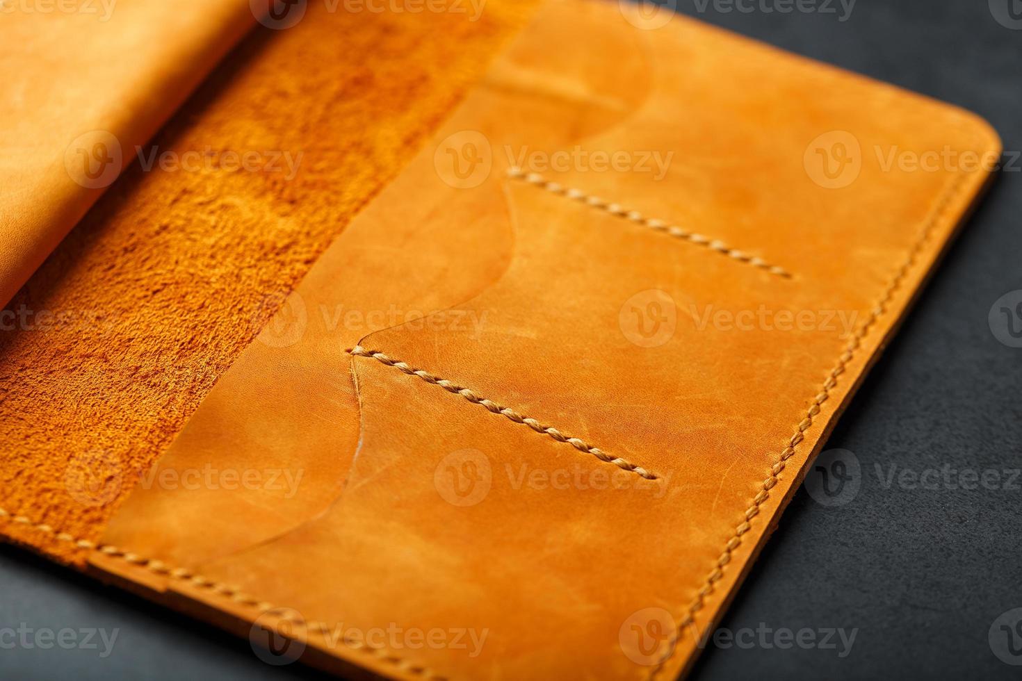bruin tas, portemonnee gemaakt van oprecht leer nubuck Aan een donker achtergrond. elementen van leer ambacht producten handgemaakt foto