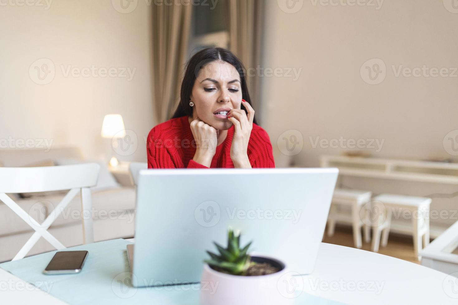 bezorgd jong vrouw gebruik makend van laptop, gevoel nerveus voorbijgaan online tentamen of afstand diploma uitreiking test Aan web, f cijfer, angstig vrouw benadrukt door slecht nieuws in e-mail, bijten nagels, op zoek Bij scherm foto