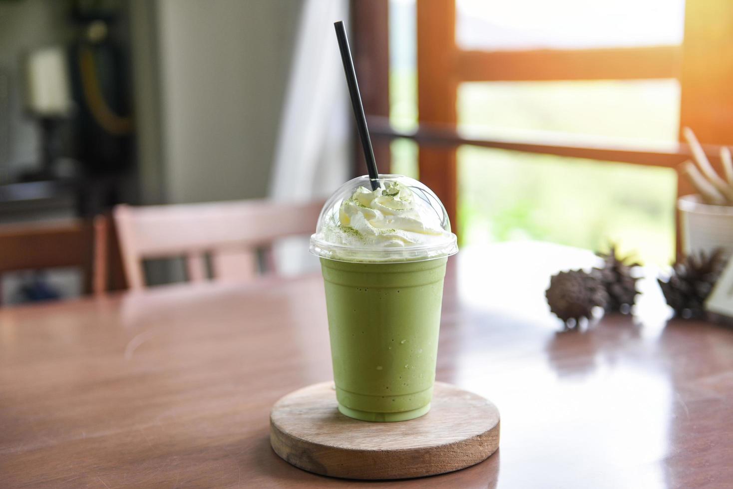 groene thee smoothie - matcha groene thee met melk op plastic glas geserveerd in een café foto
