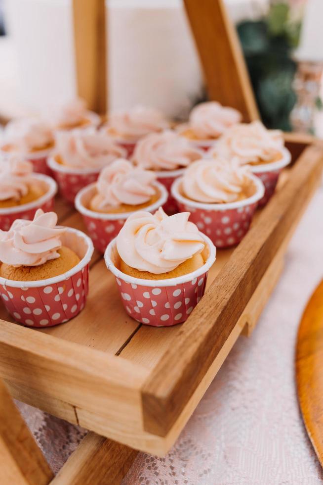 fijnproever cupcakes met wit botercrème glimmertjes en hagelslag Aan houten achtergrond foto