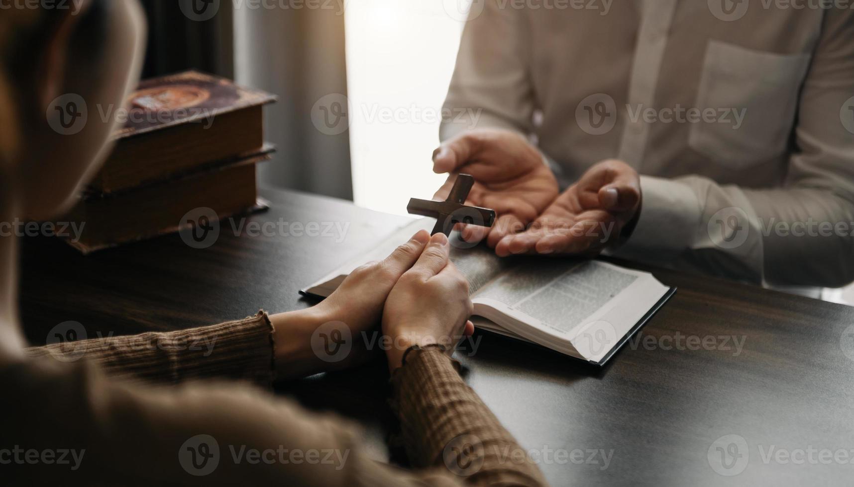 vrouw hand- met kruis .concept van hoop, vertrouwen, Christendom, geloof, kerk en bidden naar god. Aan de tafel foto