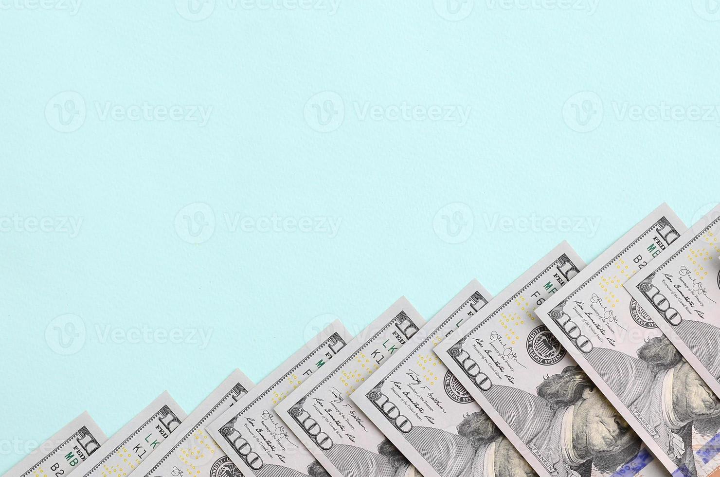 rij van een ons dollar rekeningen van een nieuw ontwerp leugens Aan een licht blauw achtergrond foto
