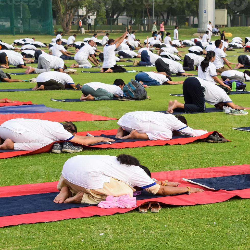 groep yoga oefening sessie voor mensen van verschillend leeftijd groepen Bij krekel stadion in Delhi Aan Internationale yoga dag, groot groep van volwassenen Bijwonen yoga sessie foto