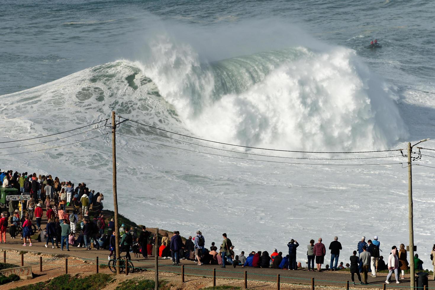 nazare, Portugal - november 7, 2022 mensen aan het kijken de groot reusachtig golven crashen in nazare, Portugal. grootste golven in de wereld. toeristisch bestemming voor surfen. foto