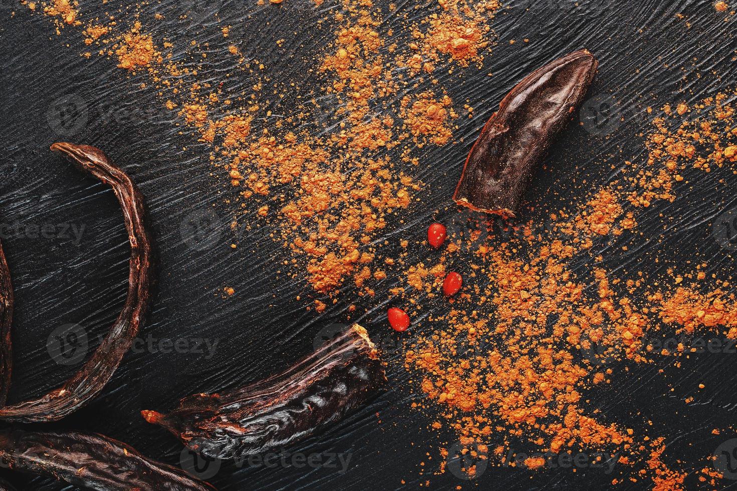 johannesbrood chocola en johannesbrood fruit poeder Aan donker achtergrond. een smakelijk en nuttig plaatsvervanger voor chocola. foto