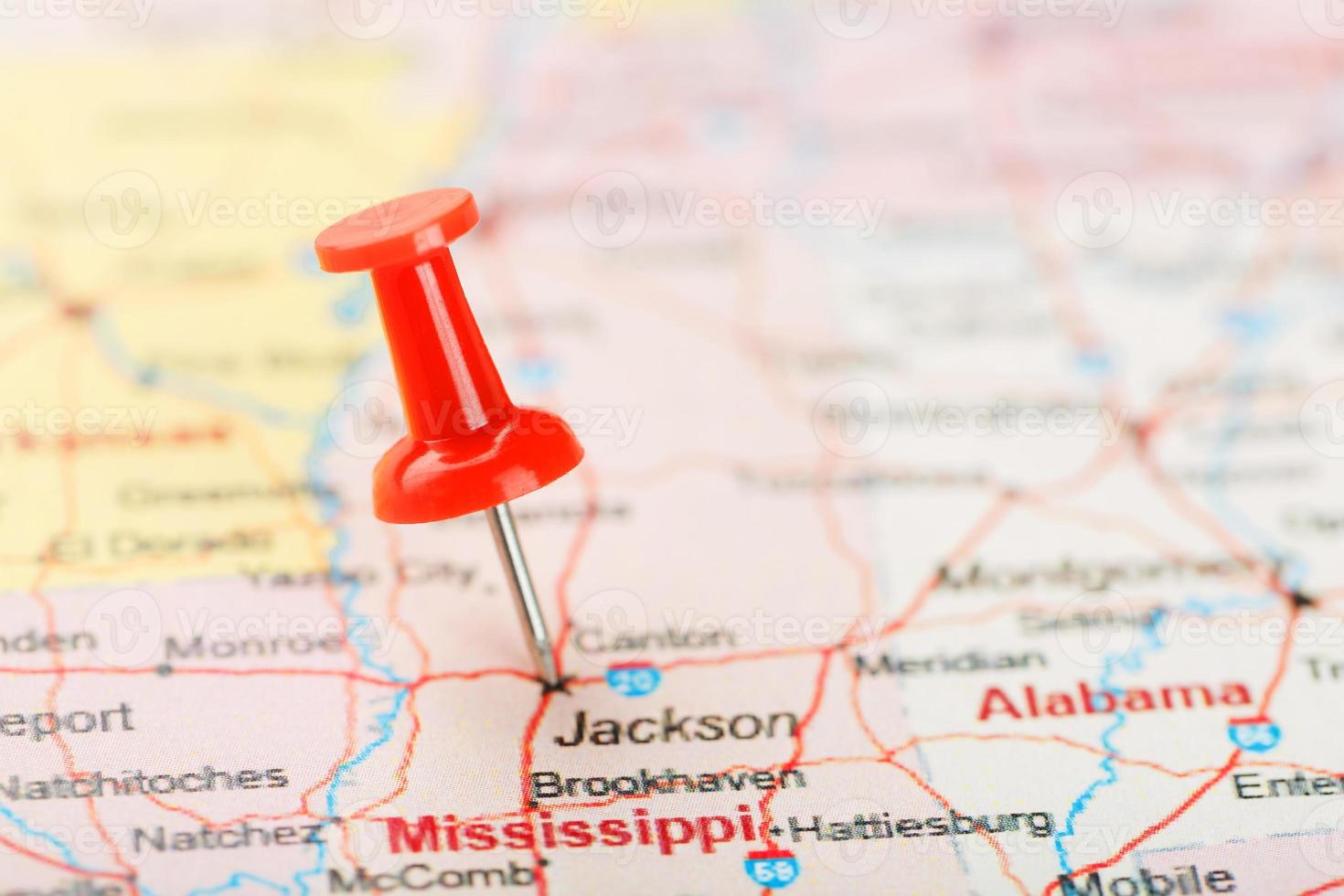 rood klerikaal naald- Aan een kaart van Verenigde Staten van Amerika, zuiden Mississippi en de hoofdstad Jackson. dichtbij omhoog kaart van zuiden Mississippi met rood tack foto