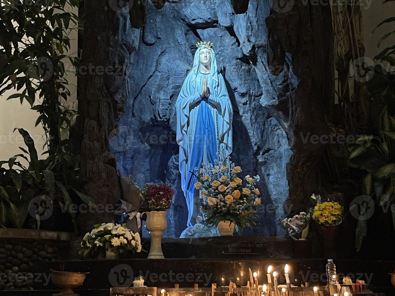 de grot van maagd Maria, standbeeld van maagd Maria in een rots grot kapel Katholiek kerk met tropisch vegetatie foto