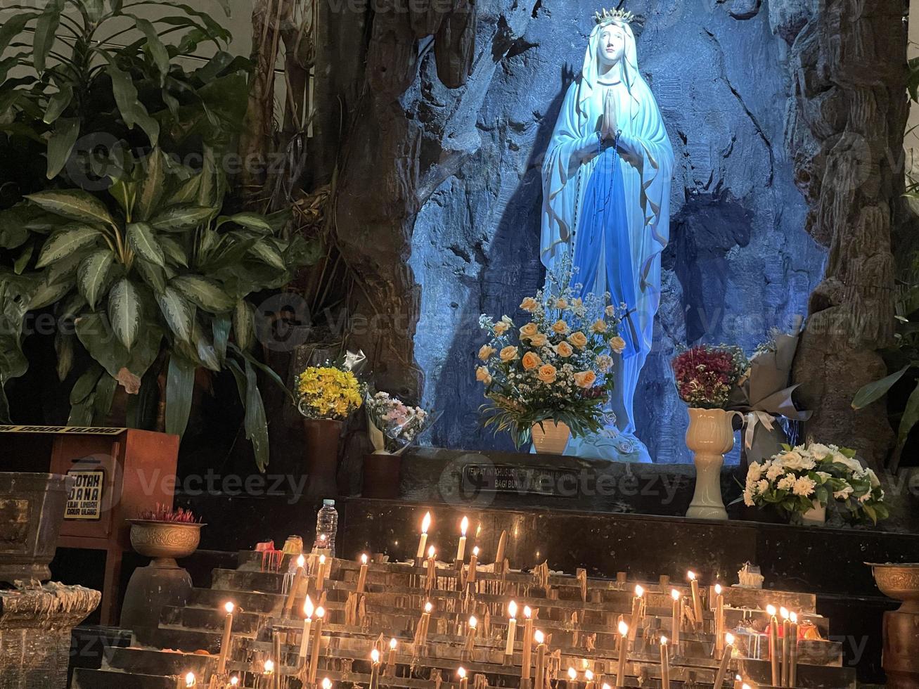 de grot van maagd Maria, standbeeld van maagd Maria in een rots grot kapel Katholiek kerk met tropisch vegetatie foto