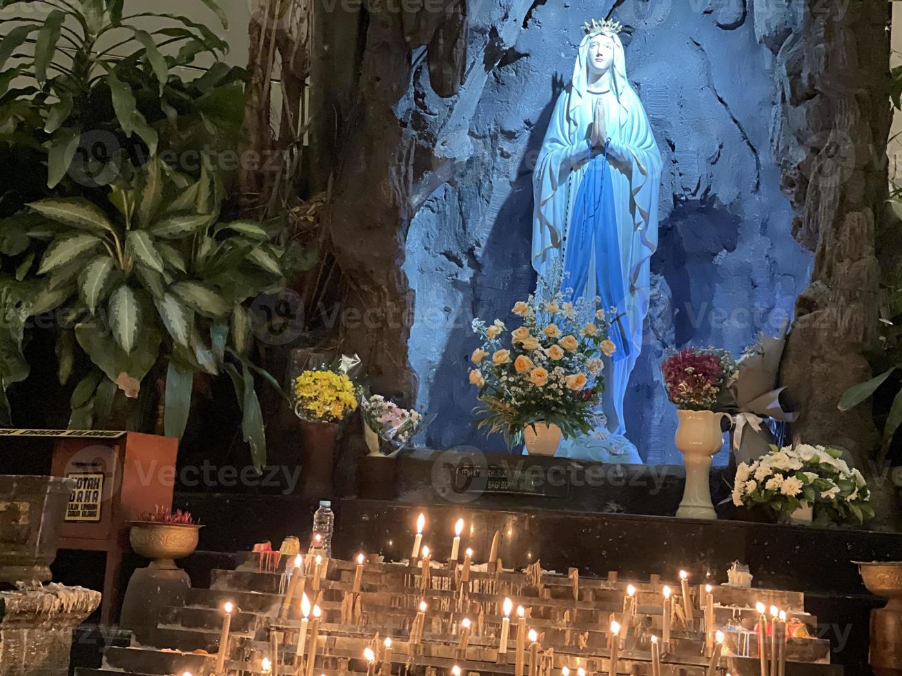 de grot van maagd Maria, standbeeld van maagd Maria in een rots grot kapel Katholiek kerk met tropisch vegetatie foto