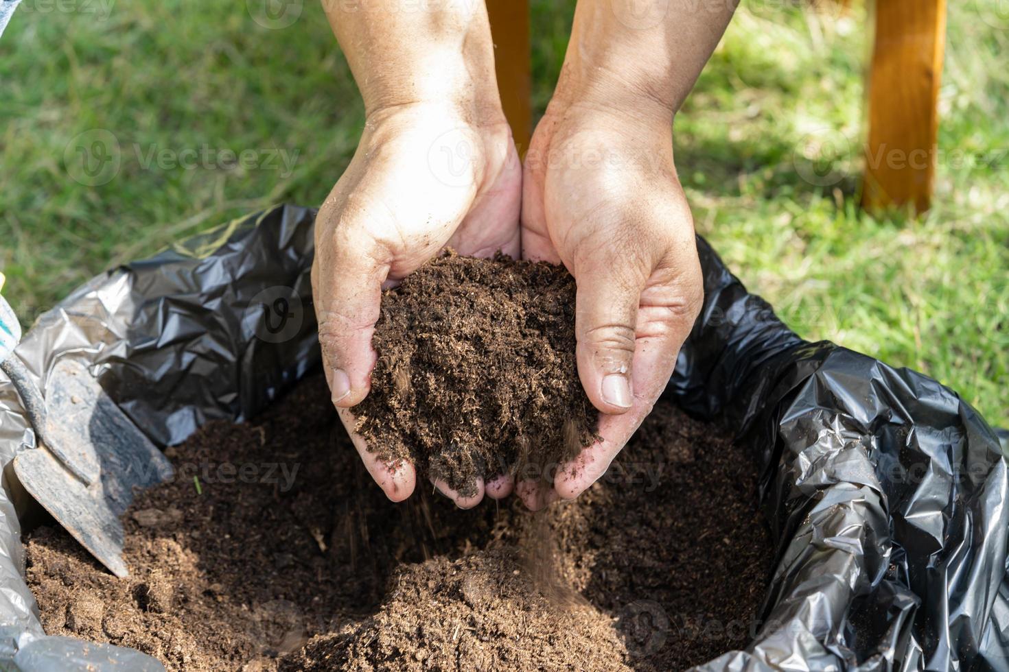 hand met veenmos organische stof verbeteren bodem voor landbouw biologische plantenteelt, ecologie concept. foto