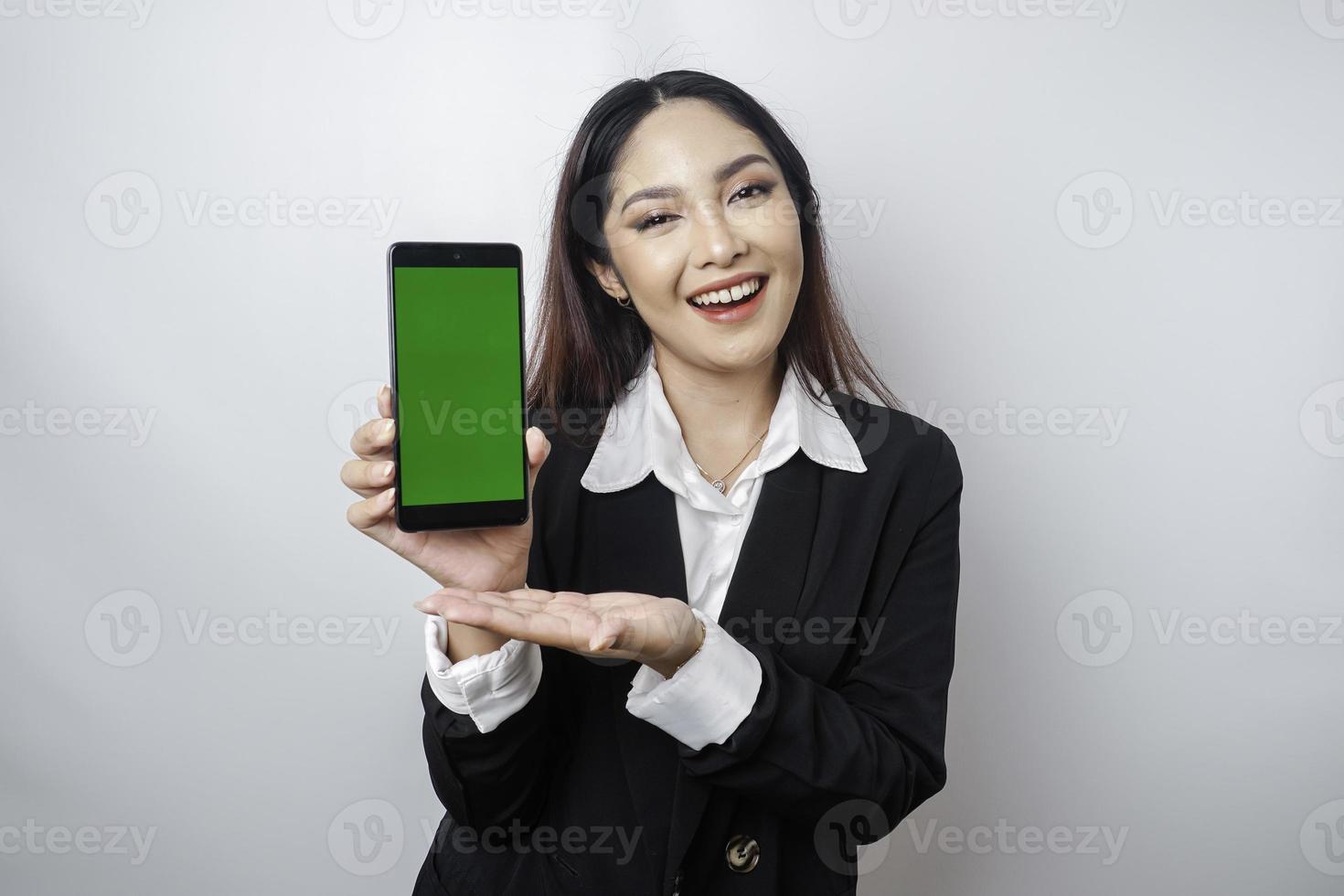 een gelukkig jong zakenvrouw is vervelend zwart pak, tonen kopiëren ruimte Aan haar telefoon geïsoleerd door wit achtergrond foto