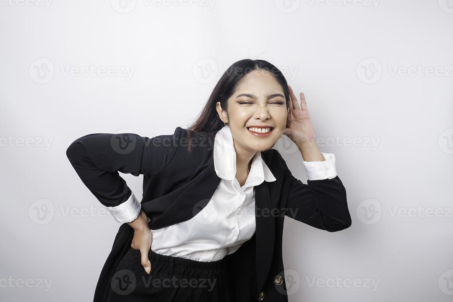 versteld staan nieuwsgierig jong vrouw vervelend een zwart pak proberen naar horen u afluisteren luisteren aandachtig geïsoleerd Aan een wit achtergrond studio portret. foto