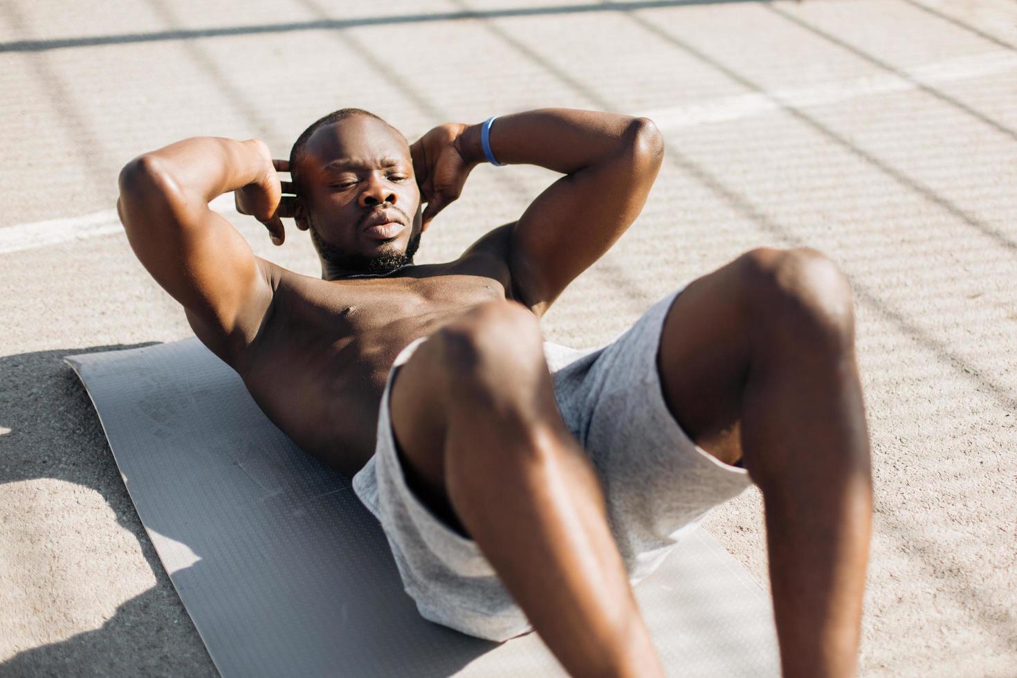 Afro-Amerikaanse man traint zijn buikspieren foto