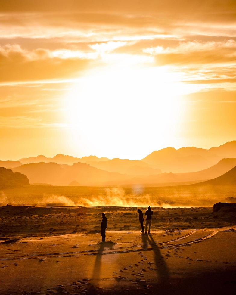 drie mannen bij de zandduinen tijdens gouden uur foto