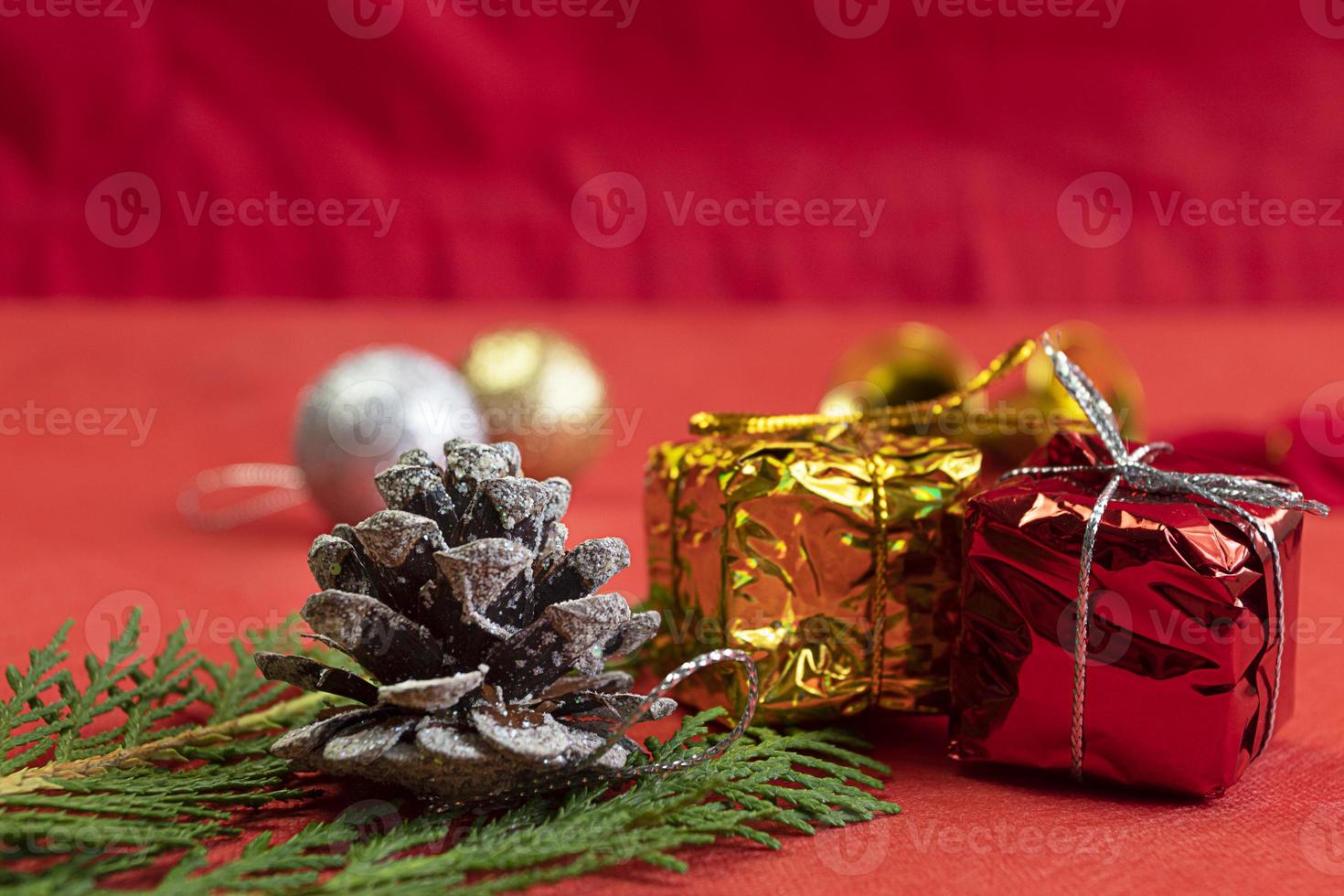 Kerstmis samenstelling. Kerstmis rood decoraties, Spar boom takken Aan rood achtergrond met pijnboom kegels decoraties. foto