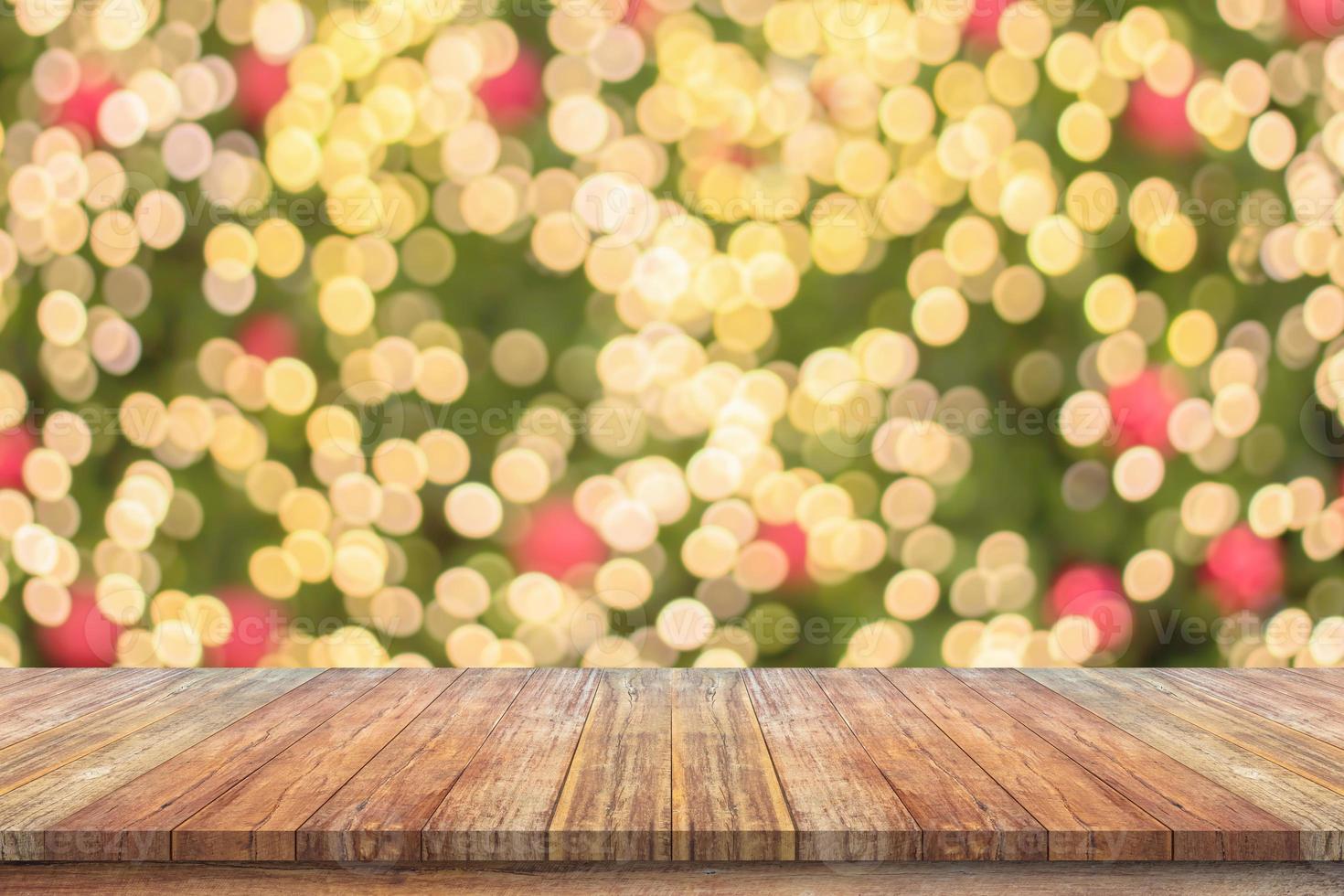 leeg hout tafel top met vervagen Kerstmis boom met bokeh licht achtergrond foto
