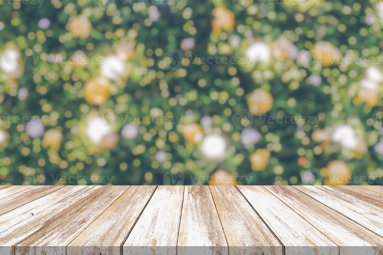 leeg hout tafel top met vervagen Kerstmis boom met bokeh licht achtergrond foto