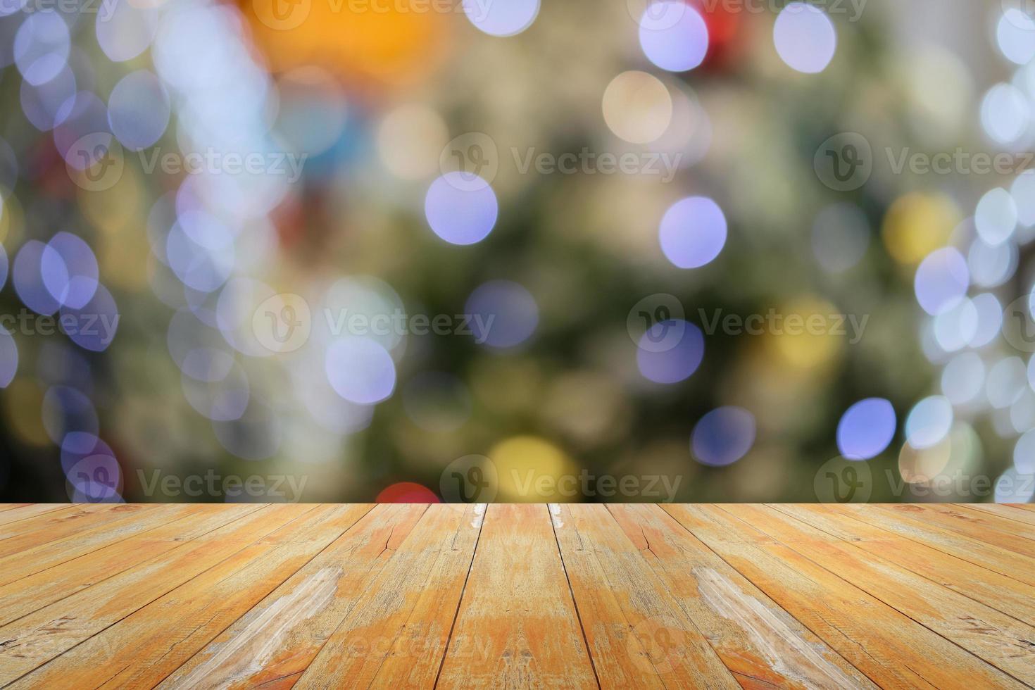 leeg hout tafel top met vervagen Kerstmis boom met bokeh licht achtergrond foto