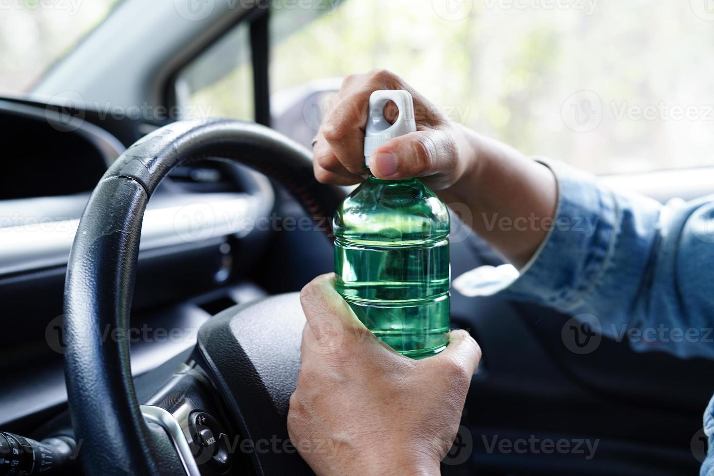 Aziatisch vrouw bestuurder houden verkoudheid water voor drinken in auto, gevaarlijk en risico een ongeluk. foto