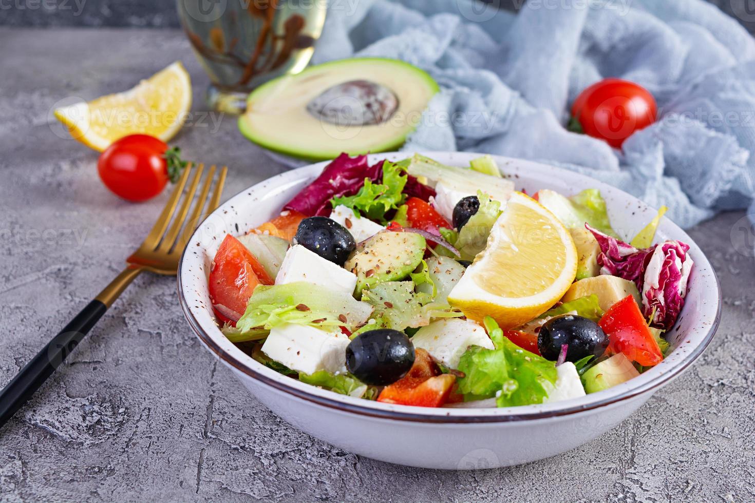 vers salade met tomaat, sla, avocado, olijven, feta en peper. eetpatroon aan het eten foto