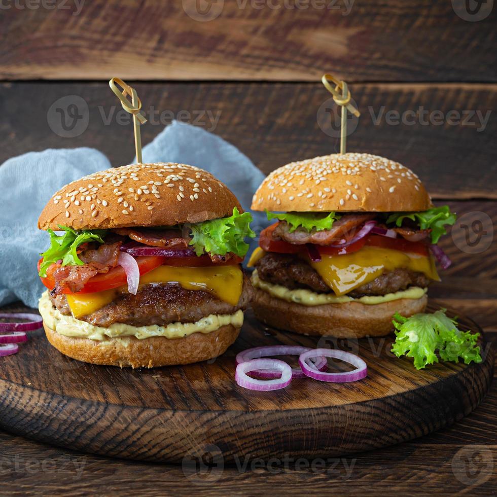 heerlijk rundvlees Hamburger met spek plak, kaas, sla en tomaat. smakelijk Fast food hamburger foto