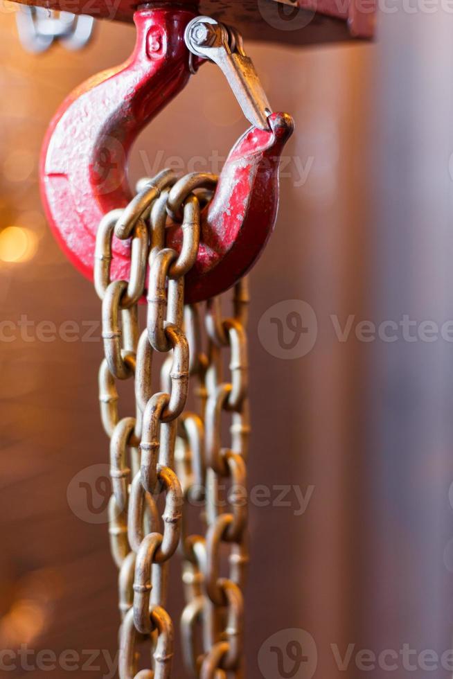 metalen keten omgaan met met rood haak in technisch kamer. kraan lading haak. foto