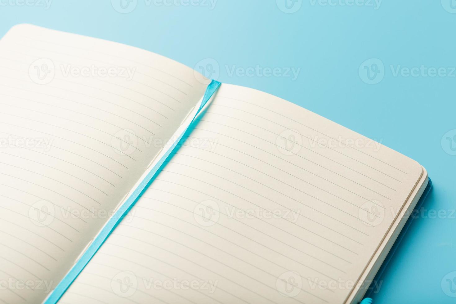 Open notitieboekje, dagboek met blanco en blanco Pagina's Aan een blauw achtergrond, top visie. foto