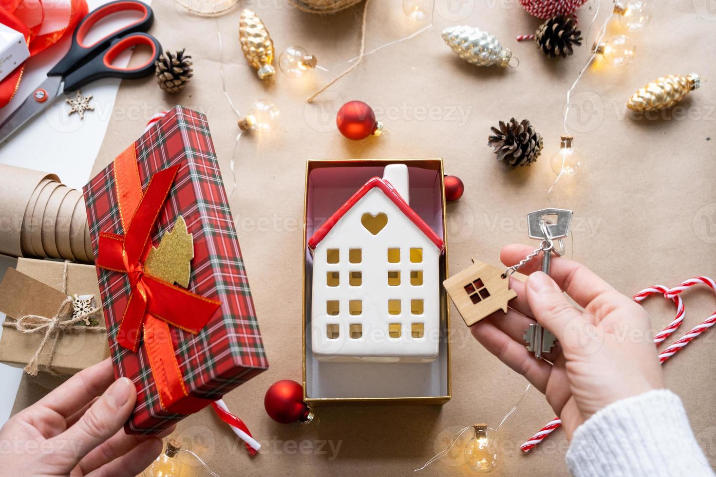 sleutel naar huis met sleutelhanger Aan knus huis in geschenk doos met Kerstmis decor verpakking. pak Cadeau voor nieuw jaar, kerstmis. gebouw, projecteren, in beweging naar nieuw huis, hypotheek, huur, aankoop echt landgoed foto