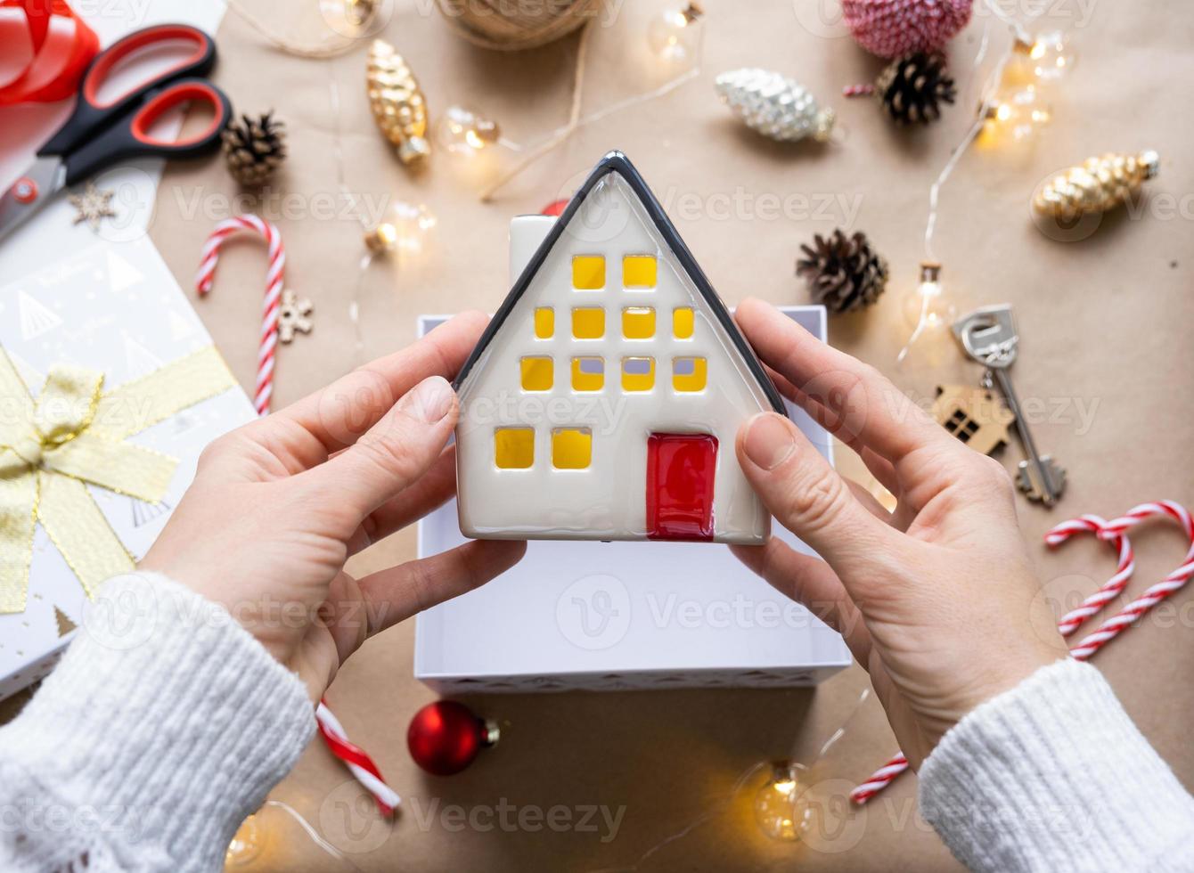 sleutel naar huis met sleutelhanger Aan knus huis in geschenk doos met Kerstmis decor verpakking. pak Cadeau voor nieuw jaar, kerstmis. gebouw, projecteren, in beweging naar nieuw huis, hypotheek, huur, aankoop echt landgoed foto