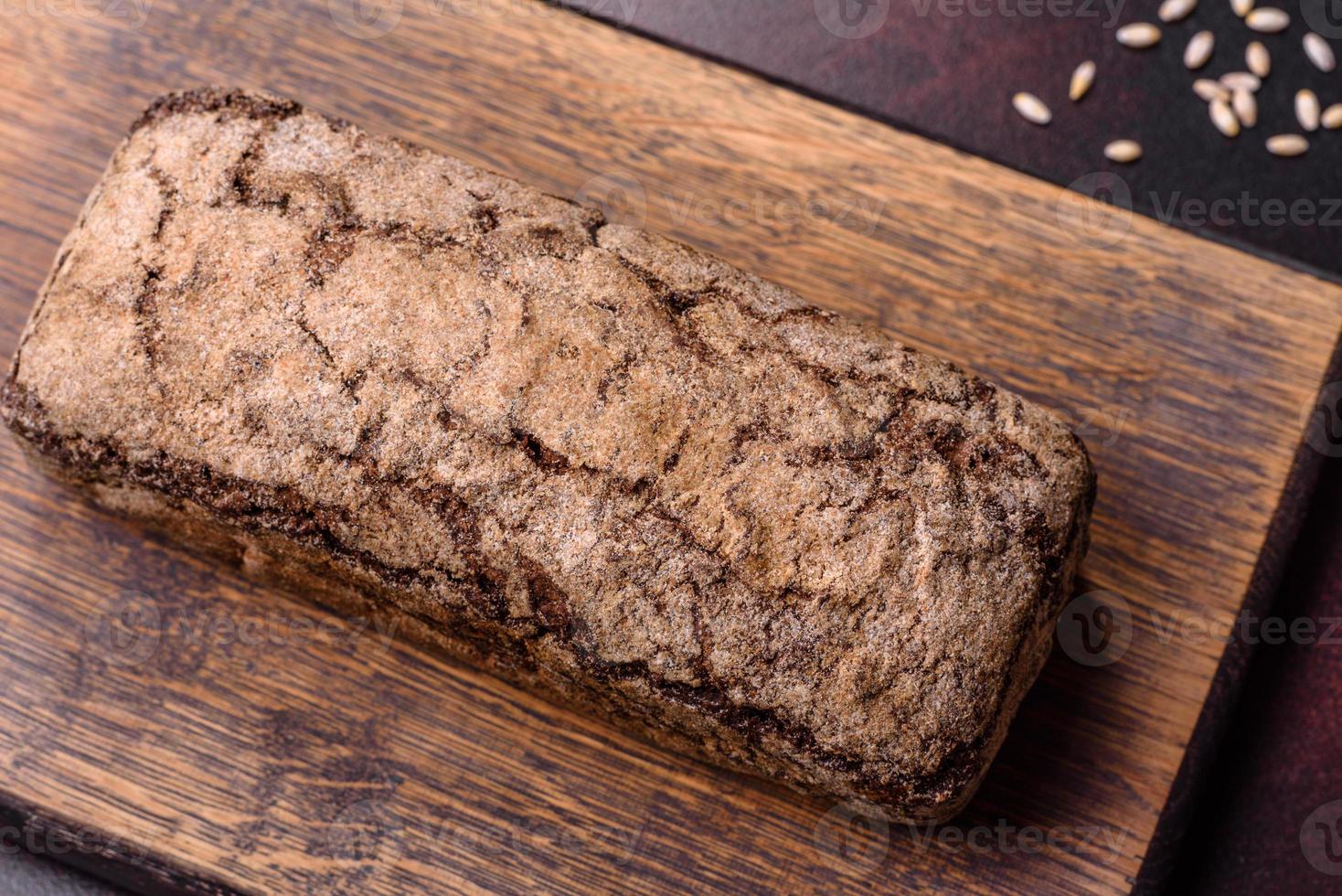 een brood van bruin brood met granen van granen Aan een houten snijdend bord foto